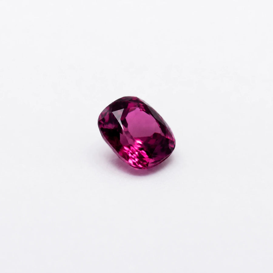 Profil incliné de cette rhodolite 1,01ct, illustrant l'épaisseur de la pierre fine et les reflets lumineux de sa couronne.