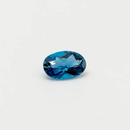 Topaze 0,53ct de taille ovale vue en biais, révélant la pureté de cette gemme et l'intensité de ses reflets bleus.
