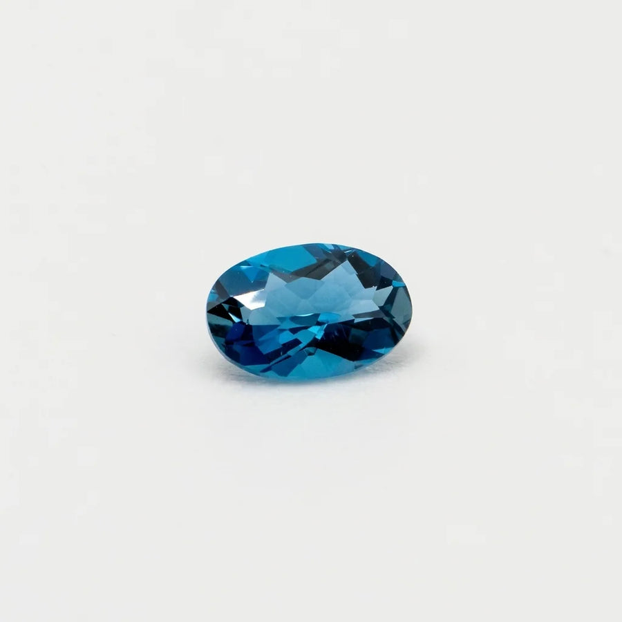Topaze 0,53ct de taille ovale vue en biais, révélant la pureté de cette gemme et l'intensité de ses reflets bleus.