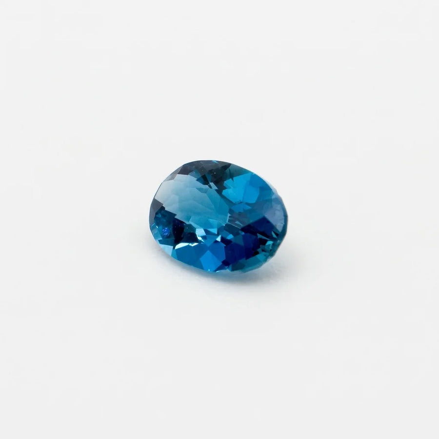 Profil incliné de cette topaze 0,53ct, illustrant l'épaisseur de la pierre fine et la géométrie de ses facettes.