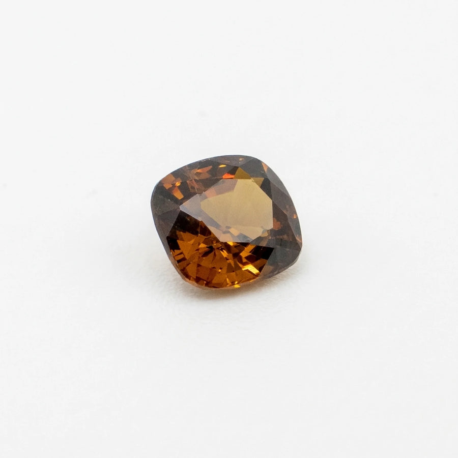 Zircon 1,43ct taille coussin vu de trois quarts, révélant la géométrie de ses facettes et ses teintes cognac.