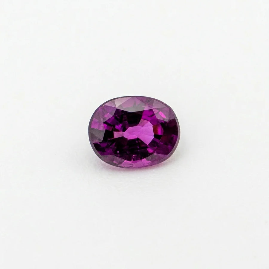 Superbe grenat raisin 0,93ct observé de face, mettant en valeur la symétrie de sa table et sa couleur magenta intense.