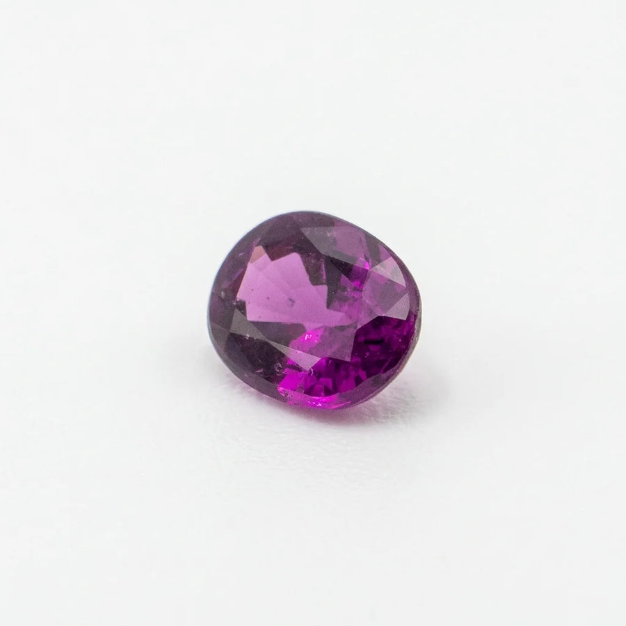 Profil incliné de ce grenat raisin 0,93ct, illustrant la profondeur de sa culasse et l'épaisseur de la gemme nue.