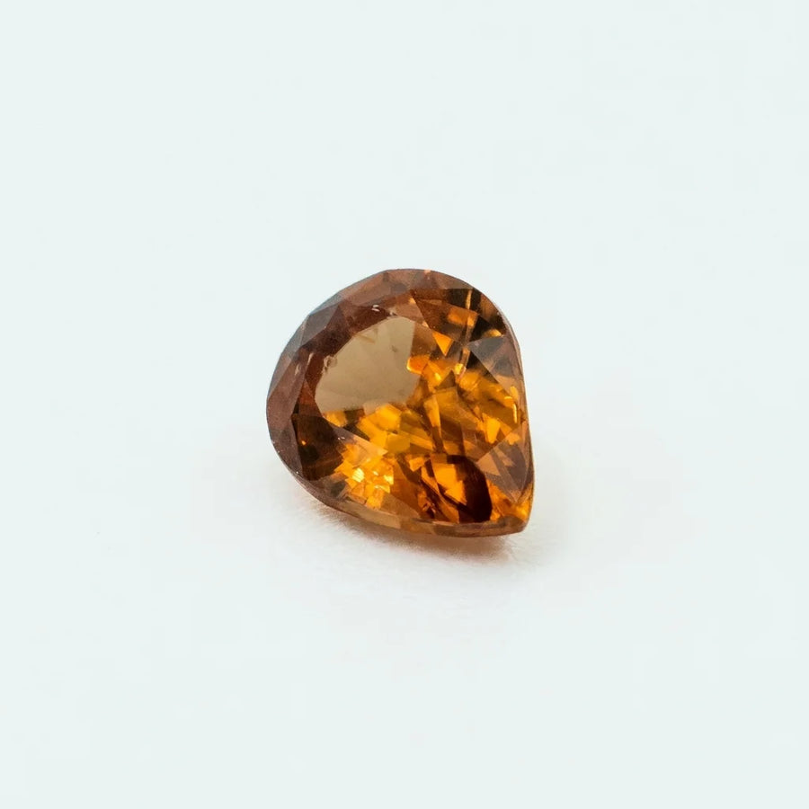 Profil incliné de ce zircon 1,50ct, illustrant la profondeur de sa culasse et les reflets dorés de la gemme.