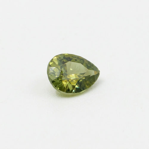 Zircon 1,55ct de taille poire vu de trois quarts, révélant la géométrie de ses facettes et ses reflets vert olive.