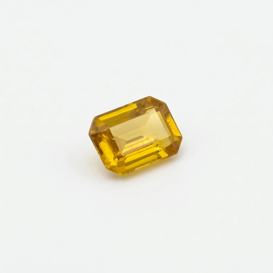 Zircon 1,10ct de taille émeraude vu de trois quarts, révélant ses reflets jaunes et la géométrie de ses facettes.