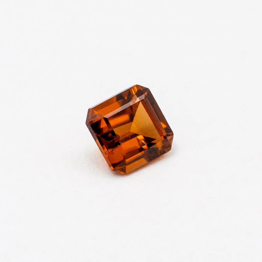 Zircon 1,75ct de taille émeraude vu de trois quarts, révélant la géométrie de ses pans coupés et son éclat orangé.