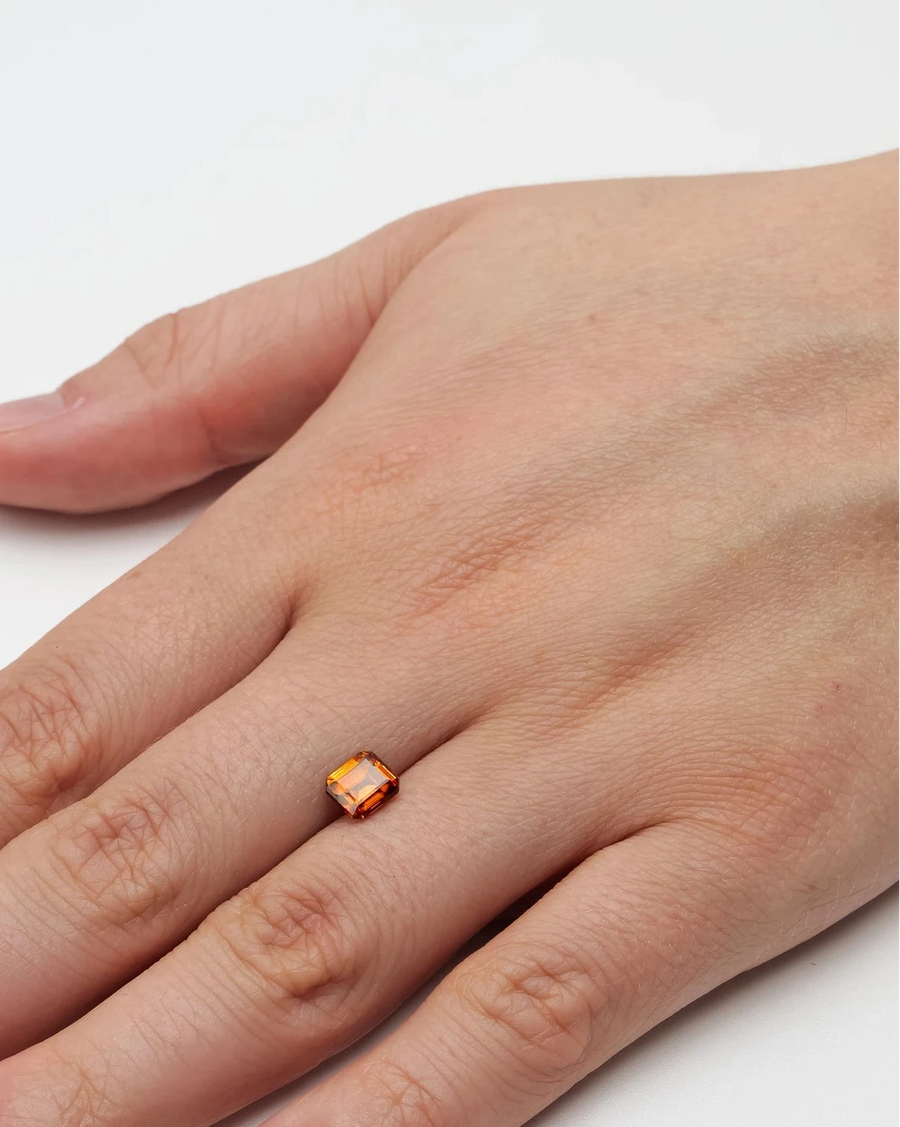 Gemme nue zircon 1,75ct posée à plat sur la peau d'une main pour donner un repère visuel concret de ses dimensions.