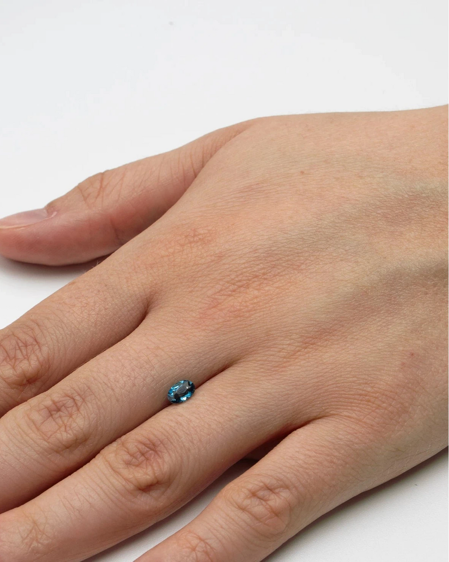 Petite pierre nue topaze 0,53ct posée à plat sur le dos d'une main pour donner un repère visuel de ses dimensions.