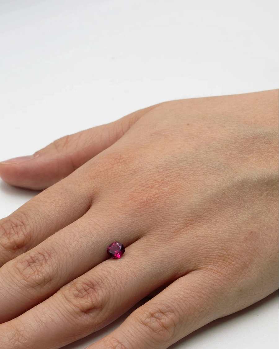 Pierre fine rhodolite 1,01ct posée sur le dos d'une main pour donner un aperçu concret de ses dimensions avant sertissage.