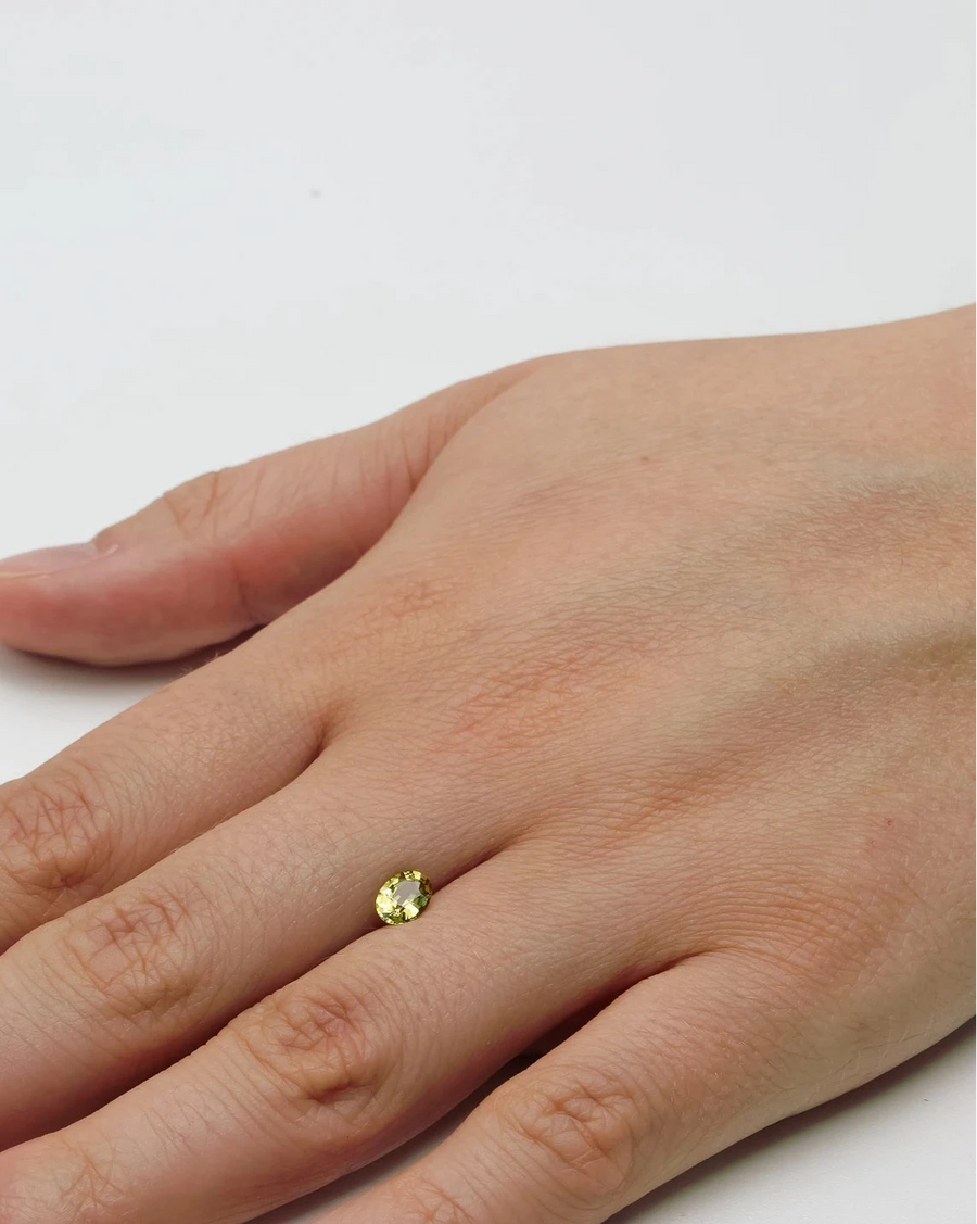 Petite pierre nue grenat Mali 0,67ct posée à plat sur le dos d'une main pour donner un repère visuel de ses dimensions.