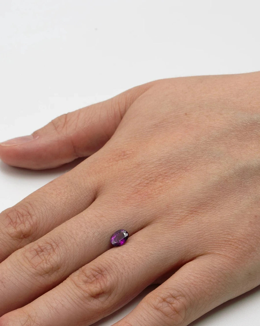 Pierre fine grenat violet 1,21ct posée sur le dos d'une main pour illustrer ses dimensions avant sertissage.