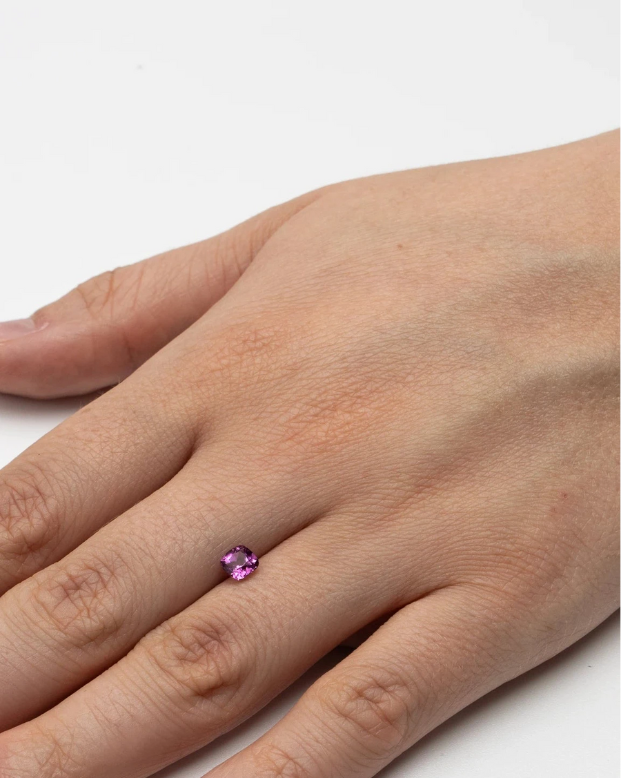Pierre fine rubellite 0,61ct posée à plat sur le dos d'une main pour donner un repère visuel concret de ses dimensions.