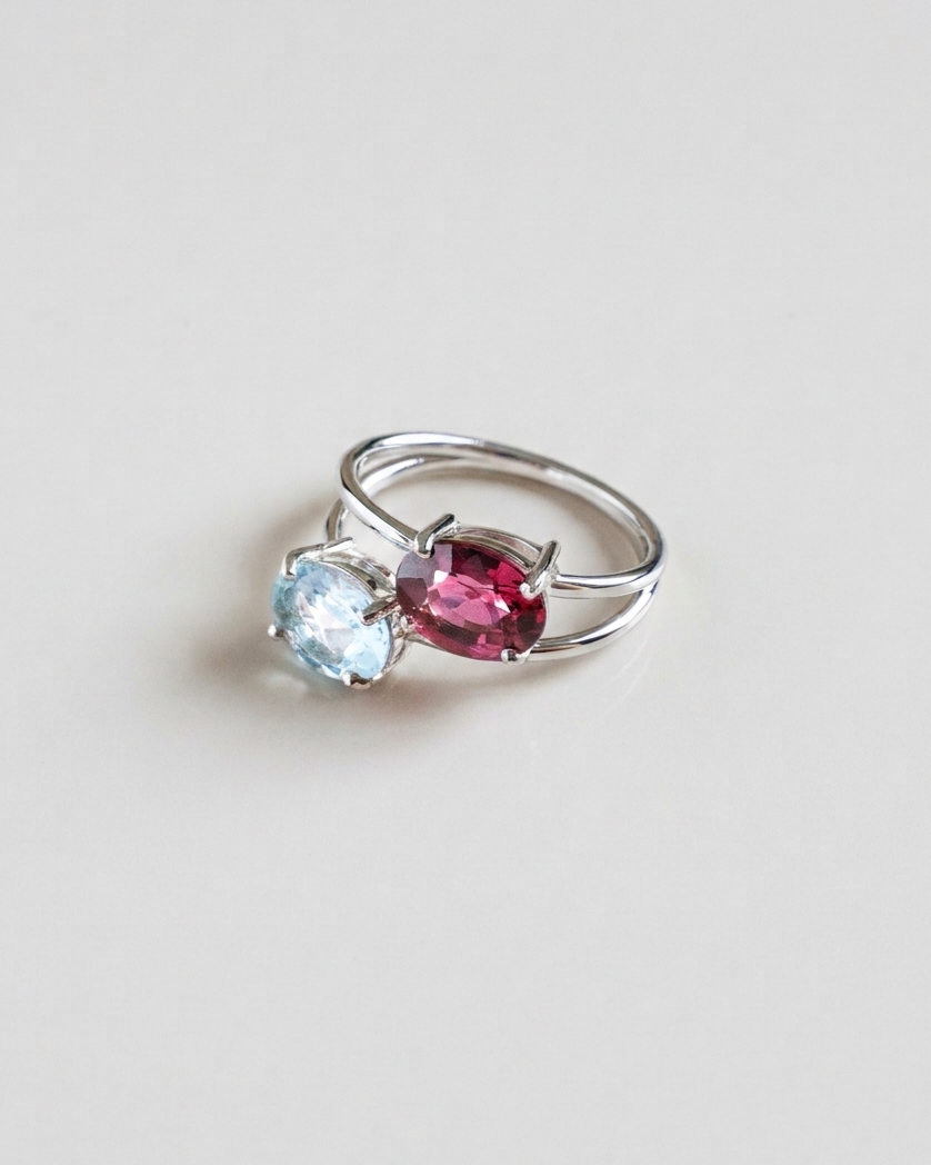 Bague Toi et Moi N°3 Rone Paris, topaze bleue et grenat sur deux anneaux d'or blanc 18 carats, vue de biais